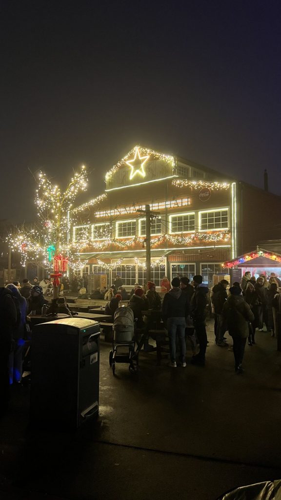 Teilnehmende des Seglertreffs Hannover stehen am Glühweinstand beim Christmas Garden 2024.
