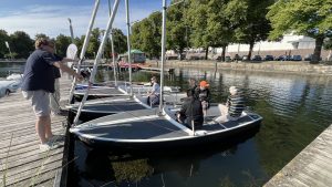 Teilnehmende des Seglertreffs Hannover segeln auf dem Maschsee, mit Blick auf die Stadtkulisse.