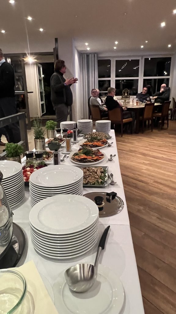 Michael Köhler hält beim Seglertreff im Hannoverschen Yachtclub einen kurzen Vortrag, daneben das vorbereitete Buffet des HYC.